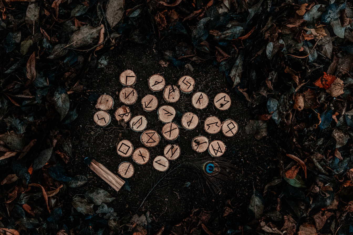 Runic Letters on Wood Chunks and Ground with Autumn Leaves 